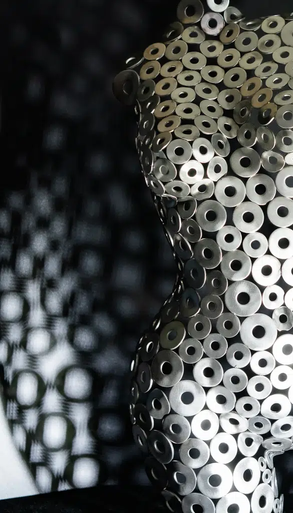 Abstract female silhouette sculpture made of polished stainless steel washers, HardDeco art.